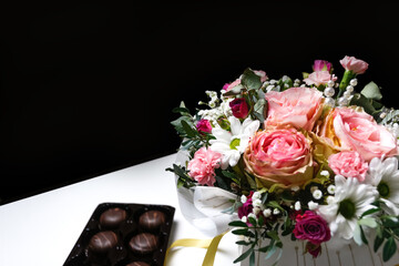 Flowers and chocolate. Flowers, bridal bouquet close-up. Decoration of roses, peonies and ornamental plants. Gift for Valentines day Women day. Mothers Day. White and black background selective focus