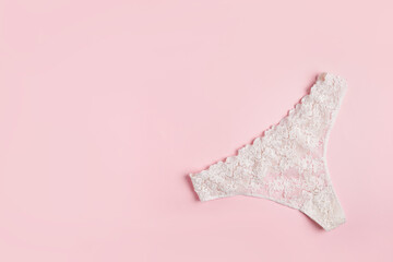 white women's panties on pink background with copy space