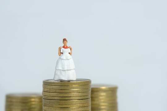 Wedding dress budget for bride, miniature people illustration concept. Woman standing above coin money stack. Image photo - Powered by Adobe