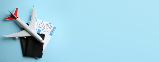 Toy airplane and passports with tickets on light blue background, flat lay. Space for text