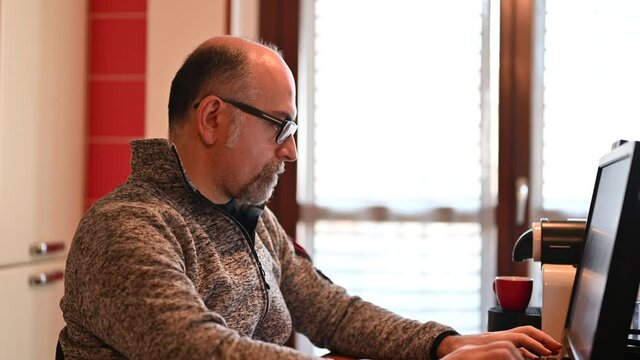 A Caucasian man working from home, is pissed off and feels isolated. Concept of stressful and demeaning work. Consequences of social distancing for the coronavirus.