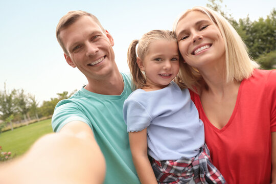 Happy family taking selfie in park on summer day