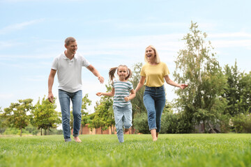 Fototapeta premium Happy family running in park on summer day