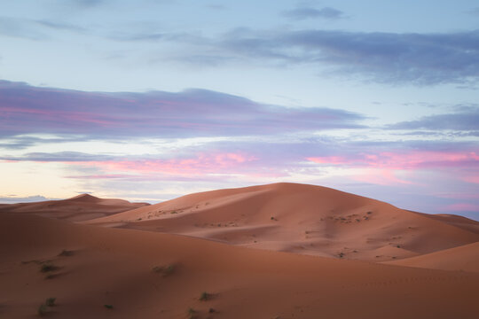A sunrise or sunset landscape view of the desert sand dunes of Erg Chebbi near the village of Merzouga, Morocco. © Stephen