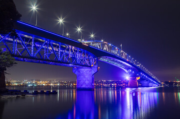 The Auckland Harbour Bridge, Auckland, New Zealand, seen at night. It is colorfully lit up to celebrate Matariki, the Maori New Year