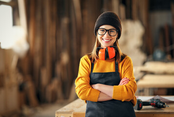 Positive woman working in joinery workshop