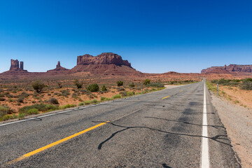 Fototapeta na wymiar Scenic view of the Monument Valley with the sandstone buttes and a road on the foreground; Concept for travel in the USA and road trip.