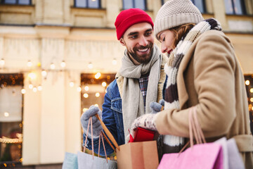 Cheerful bearded man going shopping with girlfriend in winter