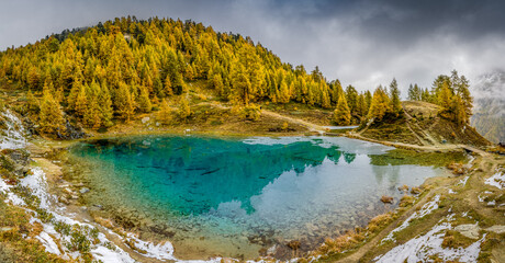 magical blue Lac Bleu with yellow larches in autumn at Arolla, Val d'Herens