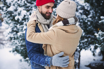 Happy young couple dating in winter forest