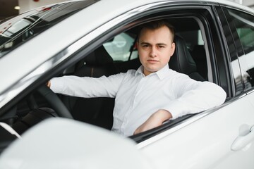 Portrait of an handsome smiling business man driving his car