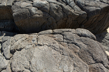 stone wall background, texture of rocks and their cracks caused by time