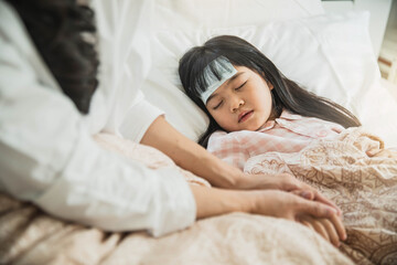 Sick little child with temperature in bed. Hand of mother on his forehead. photo of caring mother holding head on sick daughter forehead.