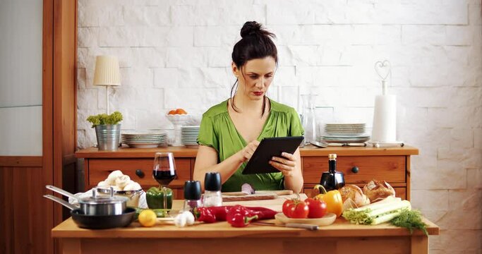 Beautiful woman checks the recipe for spring food on the tablet