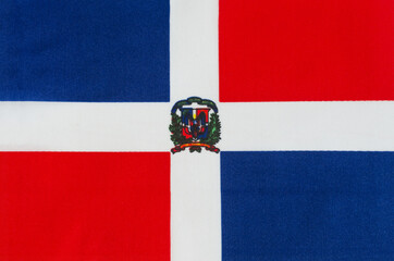 National flag of the Dominican Republic close-up on a fabric base