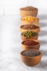 Assortment of beans, seeds, legumes on white concrete background.