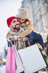 Merry woman riding boyfriend in winter city