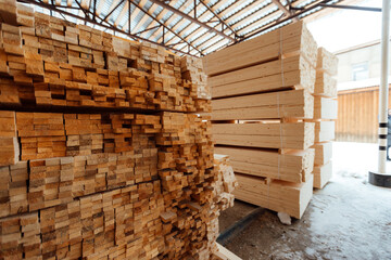 warehouse of wooden boards, background texture of wood harvested for shipment to the factory, finished products of the woodworking industry, many smooth bars of wood