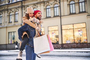 Merry young couple going shopping on winter day