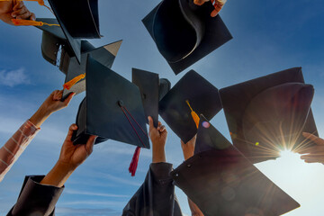 Fototapeta Graduates throwing graduation hats Up in the sky obraz