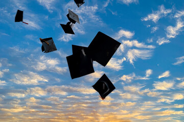 Graduates throwing graduation hats Up in the sky