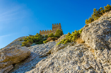 A fortress with towers on top of a cliff.