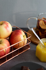 Composition of tea drinking. On a dark background, tea with dried fruits, apples, honey and chocolate. Antiviral kit. Side view 