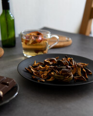 Composition of tea drinking. On a dark background, tea with dried fruits, apples, honey and chocolate. Antiviral kit. Side view 