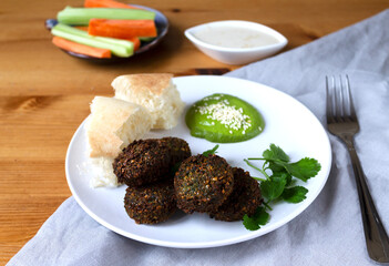 Protein lunch falafel vegetables carrots and celery bread tortilla and basil sauce