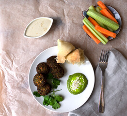 Protein lunch falafel vegetables carrots and celery bread tortilla and basil sauce