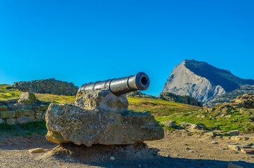 An old cast-iron cannon among the mountains.