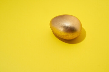 golden egg on the yellow background with shadow