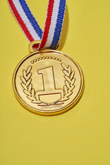 Close up of golden medal on the yellow background