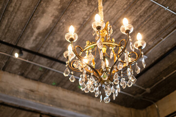Antique vintage luxury classic style chandeliers with shiny glam light decorated on wooden ceiling