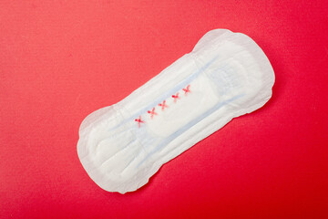 Feminine pad on a red background. Hygiene product for menstruation.