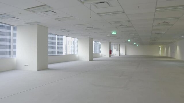 Handheld, camera moving forward &ndash; an unfurnished empty office space interior in a city high-rise after tenant move out. COVID-19 cause office space reduction. 