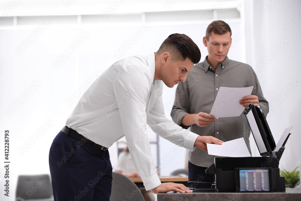 Wall mural employee using new modern printer in office