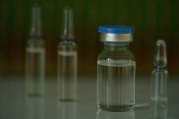 Vial for injection, blurred ampules background 