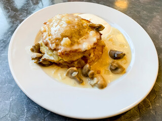 Potato pancakes, sauce with mushrooms in white plate. Studio Photo