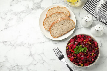 Traditional Russian salad vinaigrette served on white marble table, flat lay. Space for text