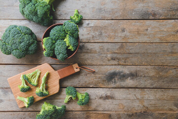 Board with fresh broccoli cabbage on wooden background
