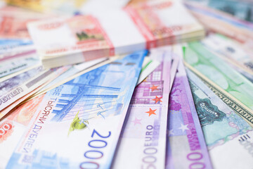 A lot of money in different currencies. A wad of money lies on the banknotes.