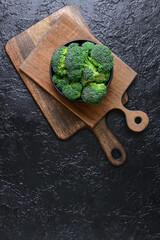 Bowl with fresh broccoli cabbage on dark background