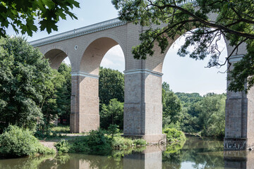 View of the high bridge over the river against the background of the forest.