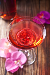 Summer tropical pink cocktail decorated purple and pink orchid flower on the wooden background