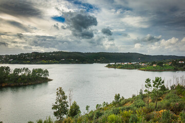 Fototapeta na wymiar Landscape view of Castelo de Bode waterdam in Portugal. Houses on the riverside of Zezere river