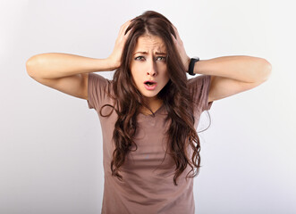 Angry young surprising business woman holding the head the hands with big eyes. Fun humor casual portrait