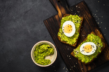 Avocado Sandwiches with Boiled Egg and Cereal Bread. Top view with space for text.