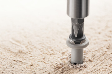 screwdriver screw and dowel in a concrete wall background