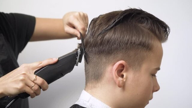 Cutting the hair at the back of the head with a hair clipper.